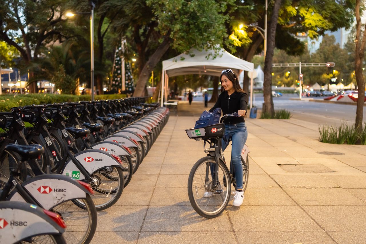 Young woman joyfully rides a rental bike in a vibrant city setting